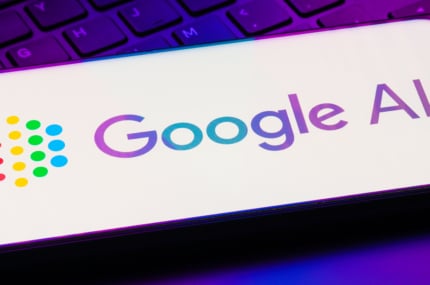 Smartphone met het Google AI-logo op het scherm, liggend op een toetsenbord met paarse verlichting.