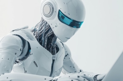 Futuristische witte humanoïde robot met een blauw verlicht vizier en zichtbare mechanische onderdelen tegen een lichte achtergrond.