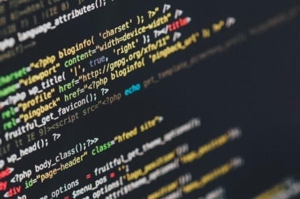 Close-up van programmeercode op een beeldscherm met HTML- en PHP-elementen.