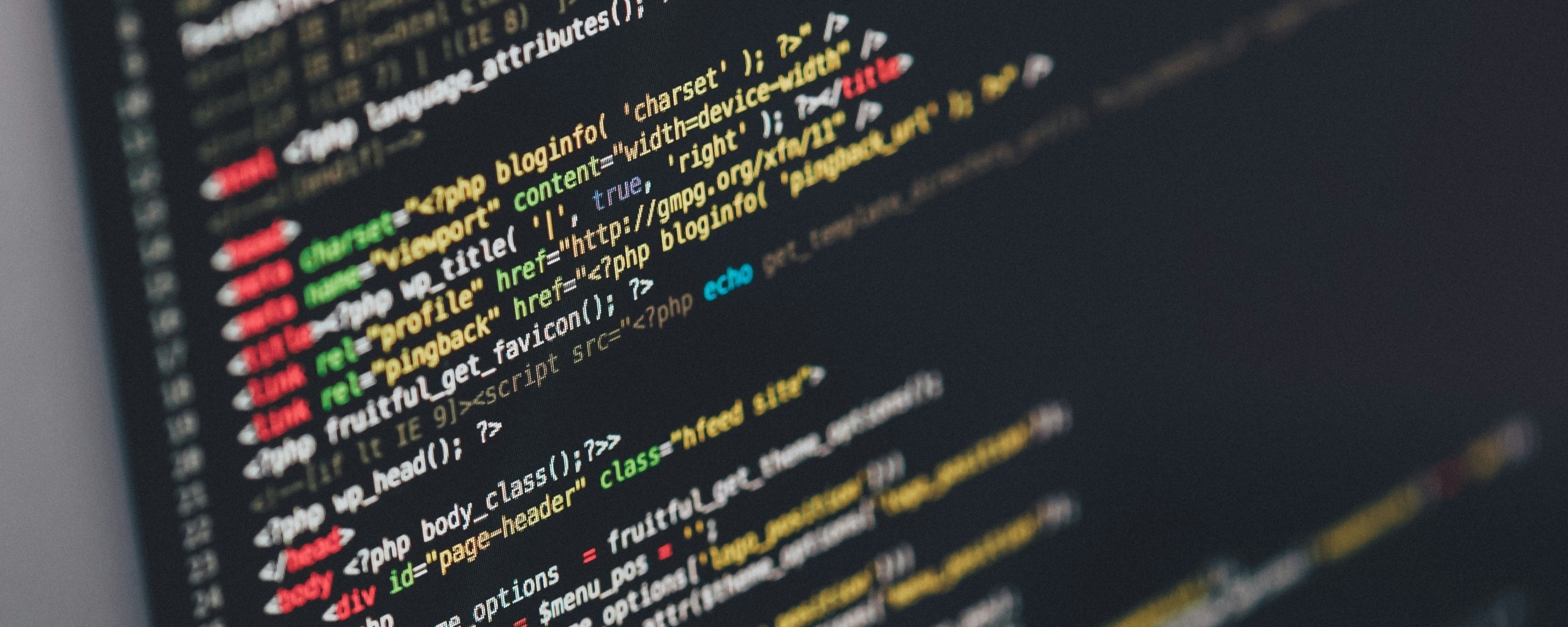 Close-up van programmeercode op een beeldscherm met HTML- en PHP-elementen.