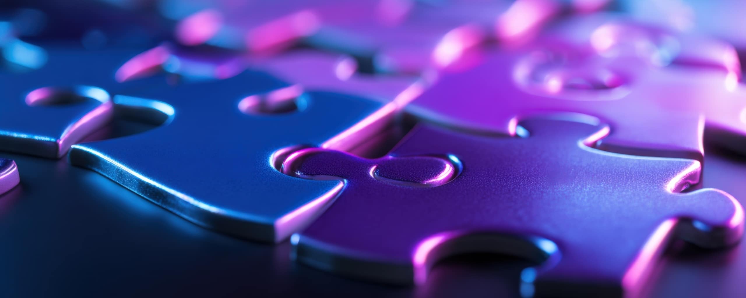 Close-up van in elkaar passende puzzelstukken met paarse en blauwe neonverlichting.